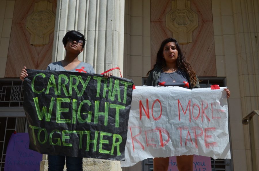 Students stand silently in protest of the current sexual assault problem on college campuses in the Carry that Weight event on April 13. 