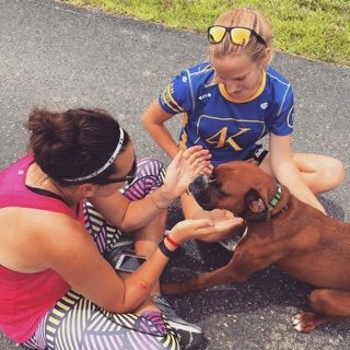 Liz Cowle, left, and MaryClaire Molina, right, play with a dog during their journey from San Francisco to Baltimore with the Ulman Cancer Fund. 