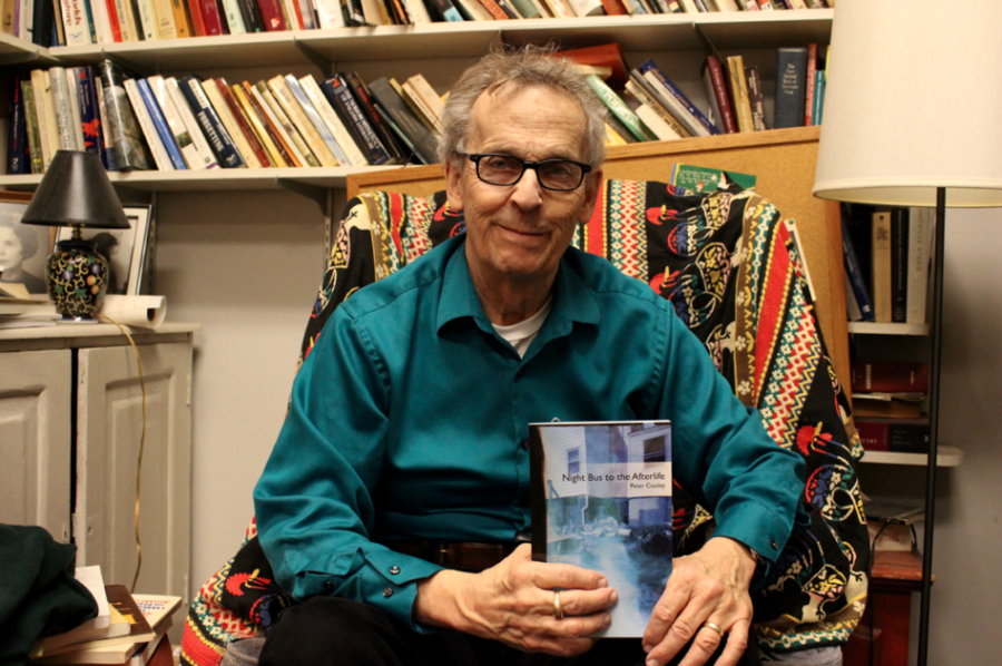 Professor Peter Cooley shows off a copy of his latest collection of poems, Night Bus to the Afterlife. He was appointed as Louisiana State Poet Laureate last fall. 