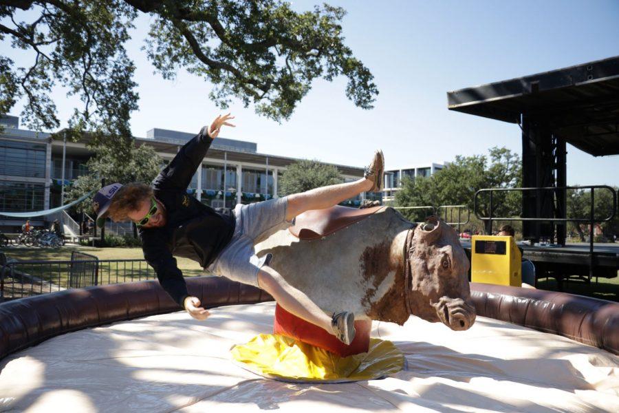 As part of the days Homecoming festivities, Homecoming King nominee Bobby Martin rides a mechanical bull Oct. 27 on the Lavin-Bernick Center Quadrangle. Other festivities for the afternoon included making emoji pillows and creating personalized signs.