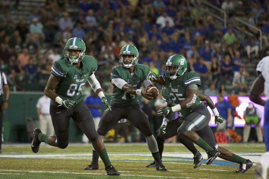 Quarterback Glen Cuiellette hands the ball off to running back Josh Rounds as receiver Larry Dace III cuts across the middle in the teams most recent game against Memphis. The Green Wave fell to the Tigers 24-14.