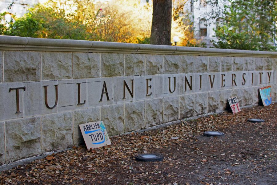 Additional signs lean against the Tulane University name monument as the protest continues.