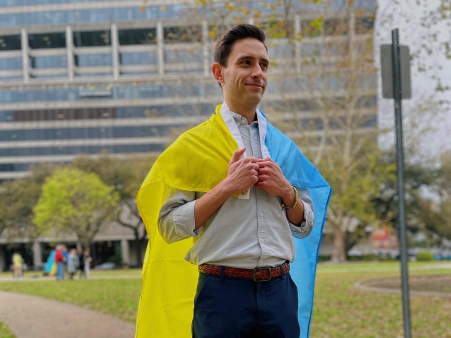 Tulane graduate student Oleksandr Orak stands with a Ukrainian flag. 