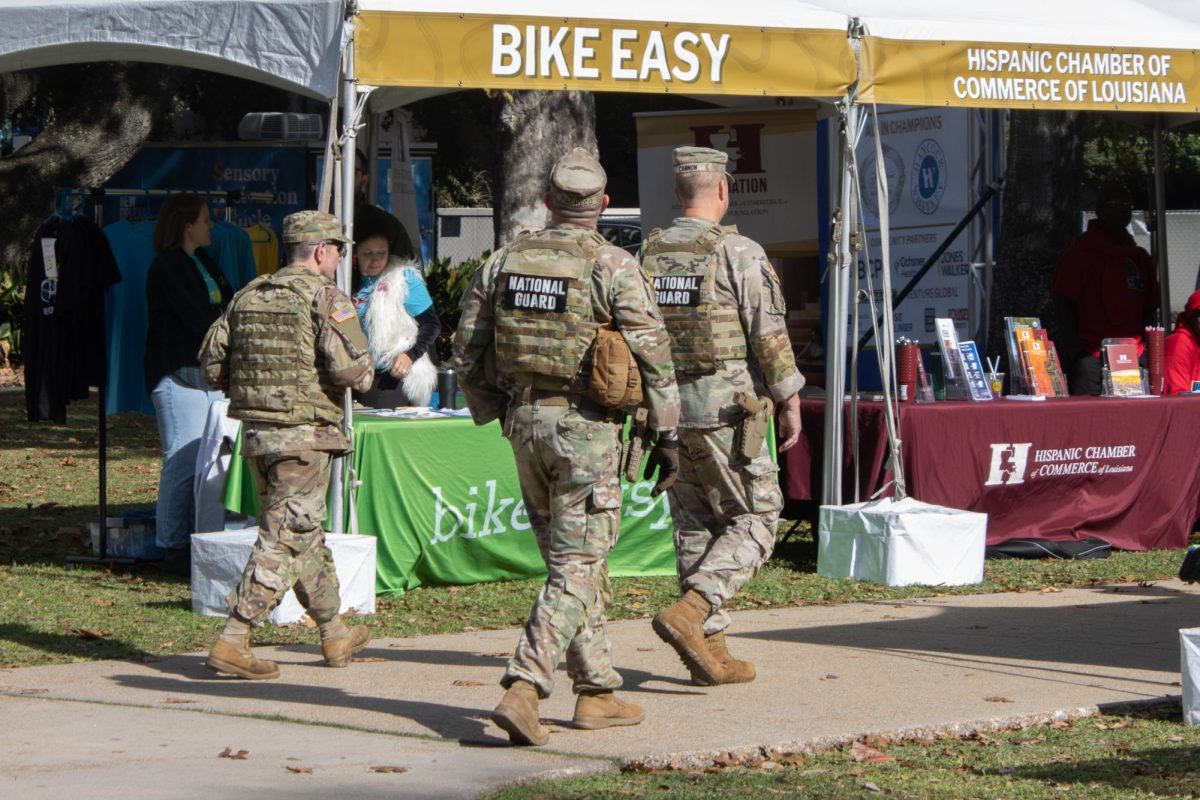 Soldiers from the Louisiana National Guard pass booths at an event celebrating the inauguration of Mayor Helena Moreno