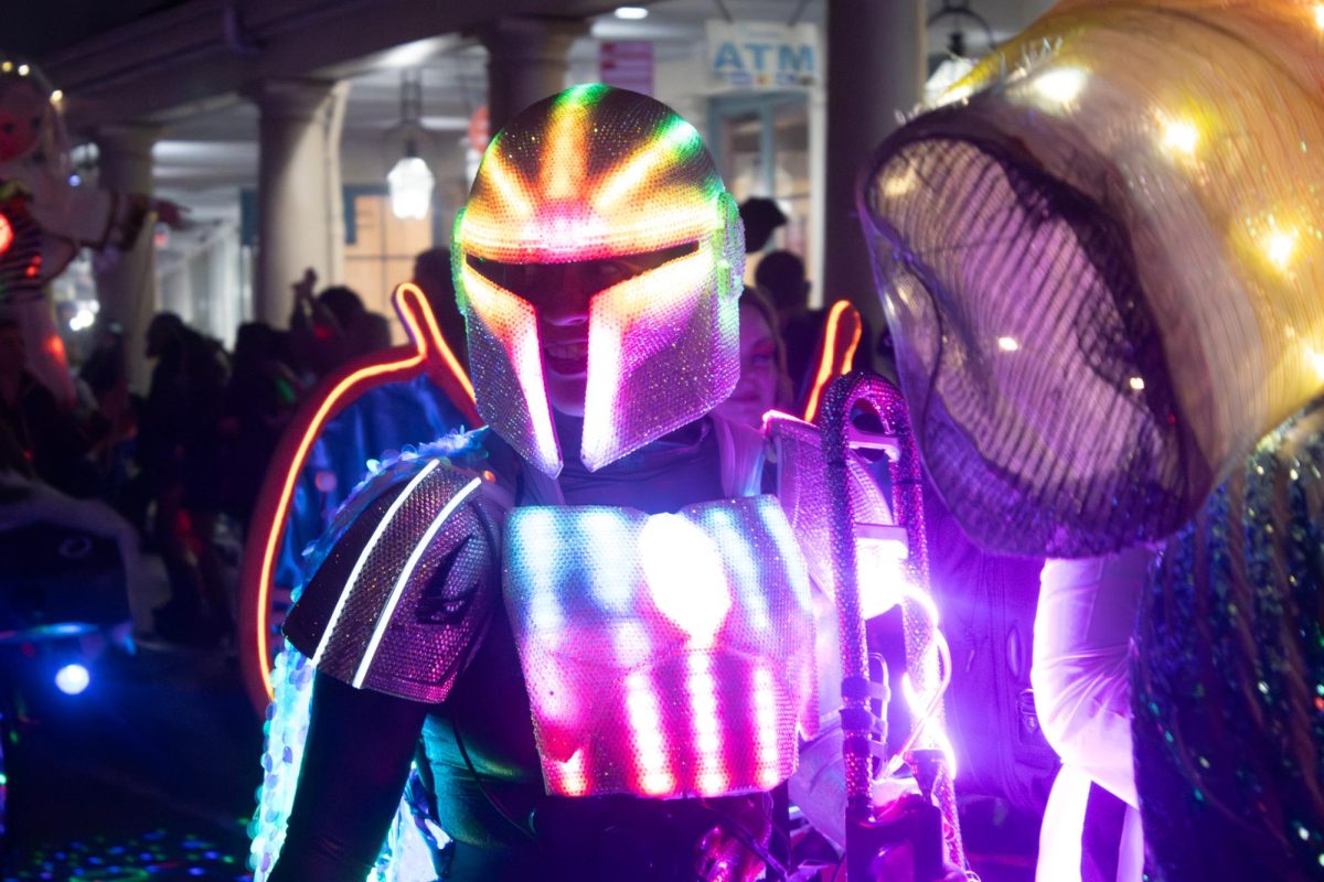 A person dressed as a custom Mandalorian from Star Wars smiles as they walk in the Intergalactic Krewe of Chewbacchus 